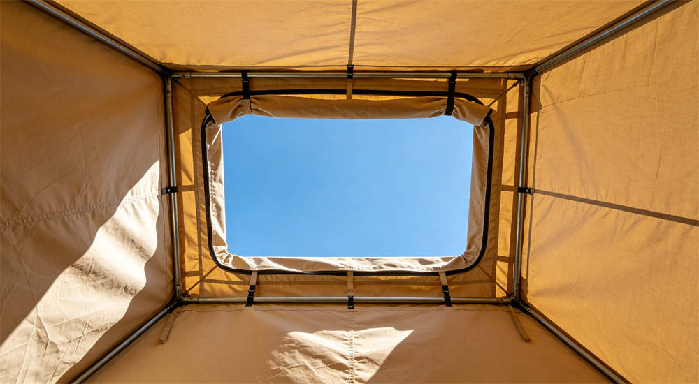 Interior view looking up at outdoor relief frame tent top ventilation in beige showing roof vent structure and ceiling fabric from inside tent