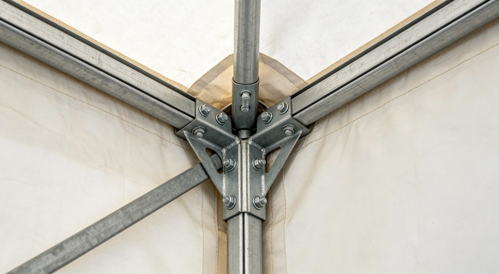 Interior view of a spacious emergency relief tent showing adequate headroom natural lighting through windows and organized living space for displaced family accommodation
