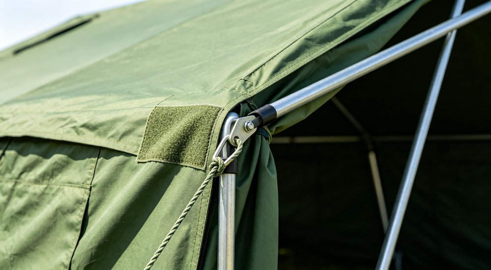 Frame tent guy lines and pole anchoring, close-up detail, green grass red and white inflatable emergency shelter for disaster relief operations