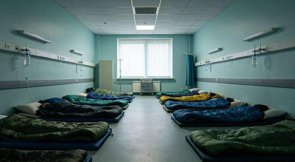 Wide angle view of hospital temporary rest area with sleeping bags for patients and medical staff Wide angle view of hospital temporary rest area with sleeping bags for patients and medical staff