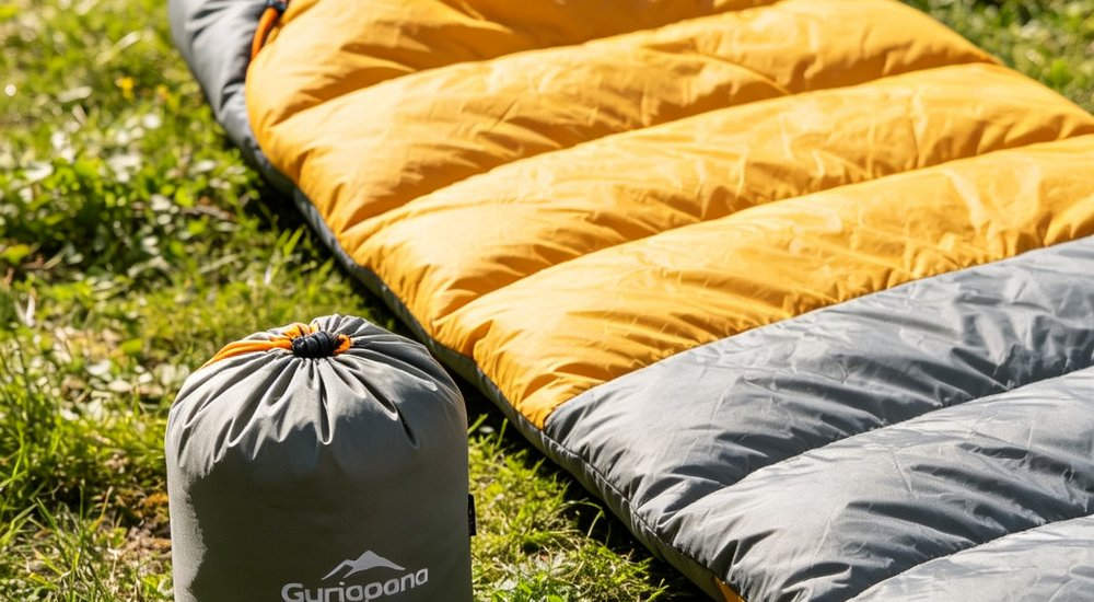 Side by side comparison view of compressed sleeping bag in small black compression sack next to uncompressed full size navy blue sleeping bag showing storage size difference and portability