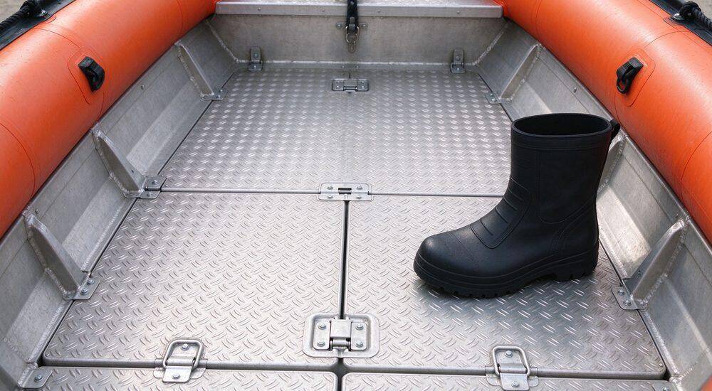 Interlocking aluminum floor panels inside inflatable rescue boat with anti-slip diamond plate surface demonstrating rigid deck support for standing rescue watercraft operations and heavy equipment loading
