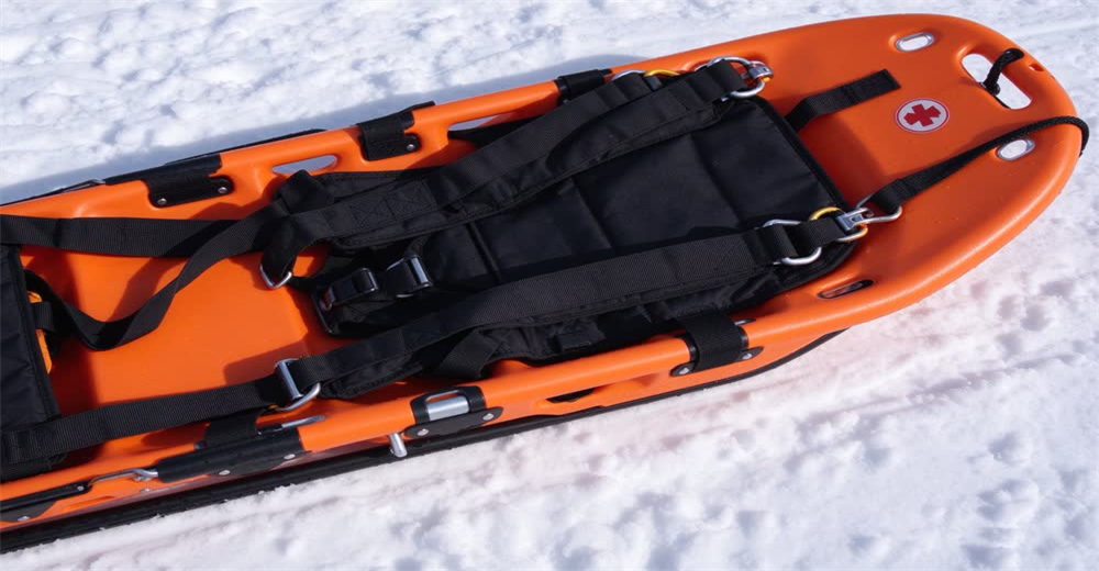 Front view of blue alpine rescue sled showing specialized patient evacuation sled for snowy terrain