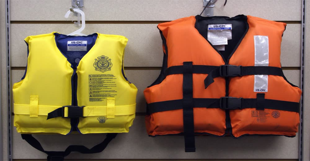 Front view of adult and child orange life jackets side by side showing family-sized personal flotation devices Front view of adult and child orange life jackets side by side showing family-sized personal flotation devices